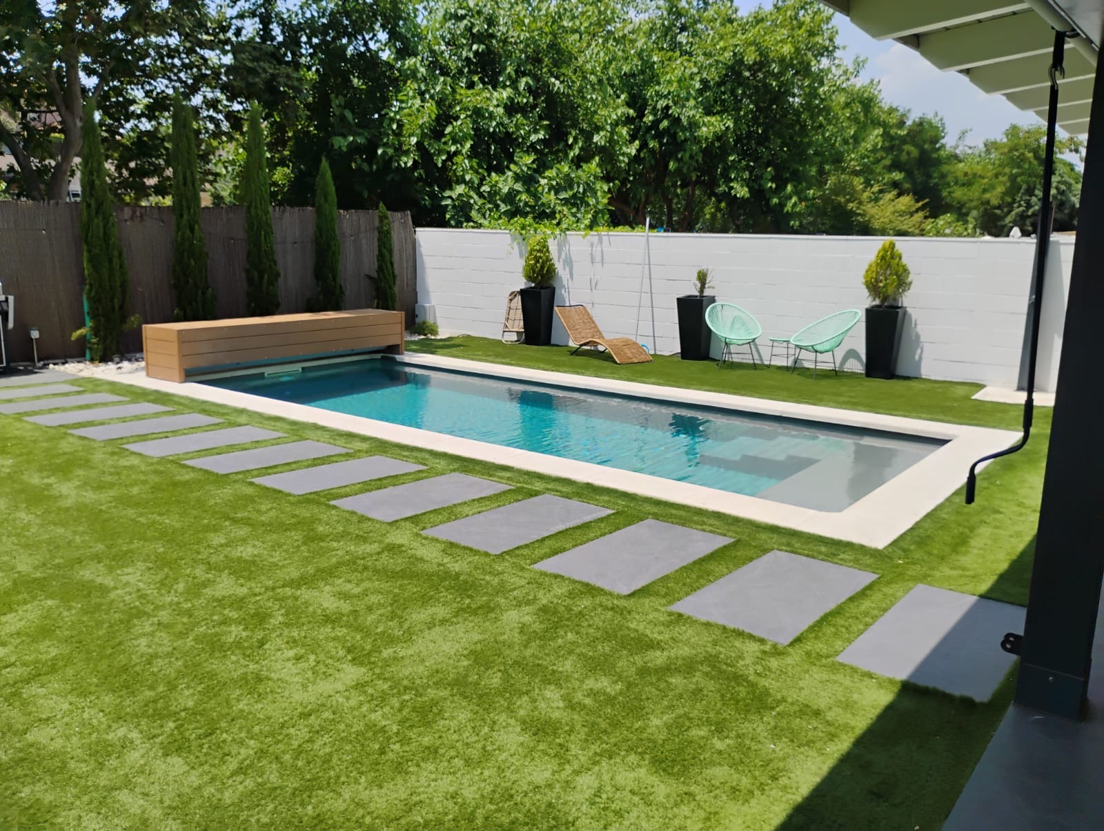 Cubierta automática de piscina integrada en jardín con césped y ambiente familiar